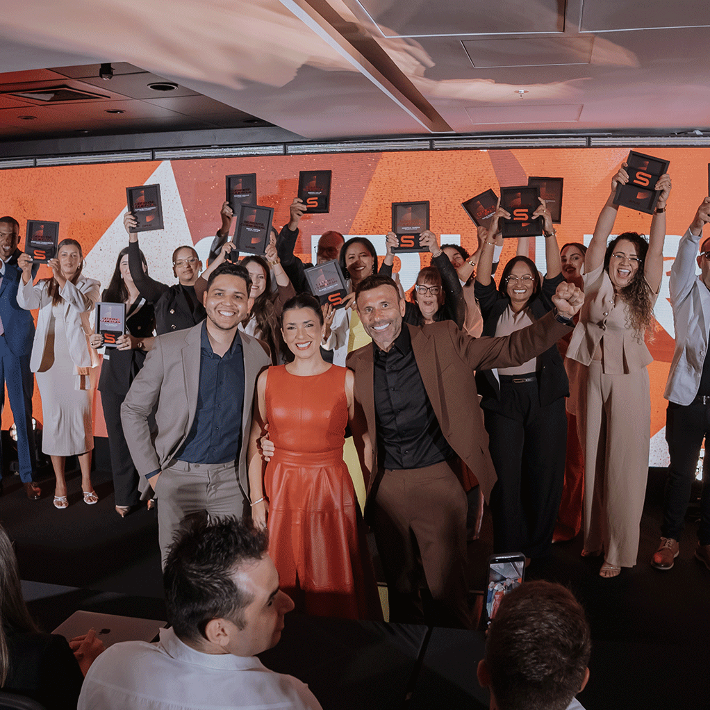Arthur Queiroz, Samanta Sanchez e Eduardo Carmo com alunos que se tornaram gerentes levantando a placa do SPUR no evento SPUR Legacy